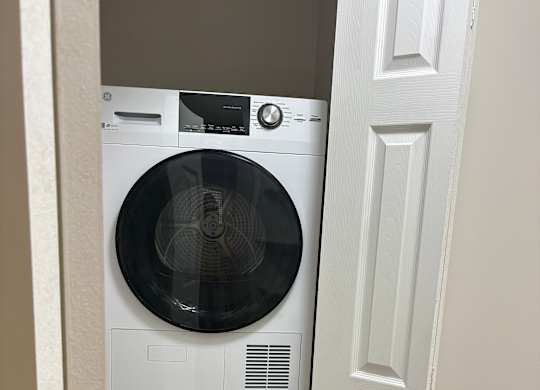 Two front loading washing machines are installed under a cabinet.
