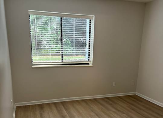 A room with a window and a wooden ceiling.