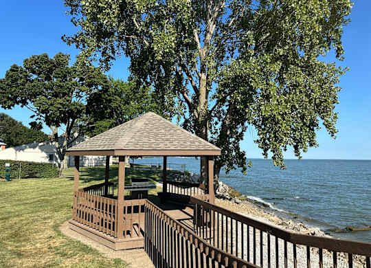 A gazebo sits on a wooden deck overlooking Lake Erie