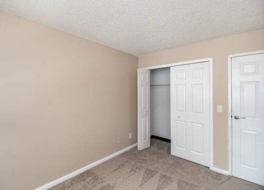 A room with a white door and a white closet door.