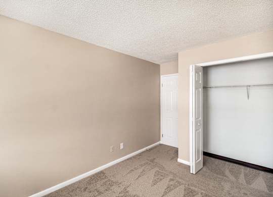 A room with a white door and a carpeted floor.