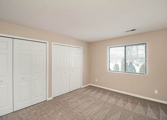 A room with white doors and a carpeted floor.