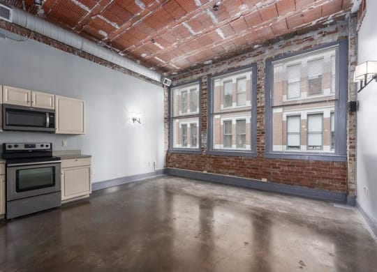 a kitchen with a stove top oven next to a window at East 4th Street, Cleveland, OH