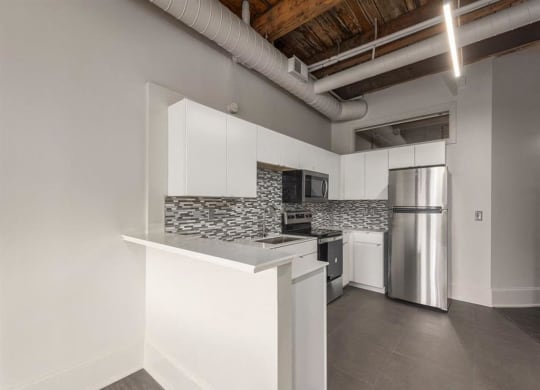a kitchen with white cabinets and a stainless steel refrigerator