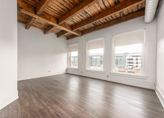 an empty room with white walls and a wooden ceiling