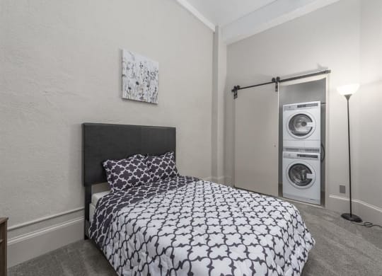 a bedroom with a bed and a washer and dryer
