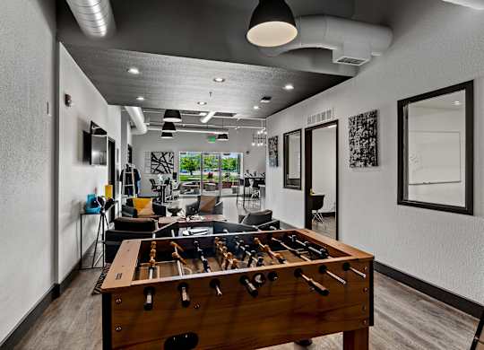 A room with a pool table and a foosball table. at Vivo Toledo Apartments, Toledo, OH, 43607