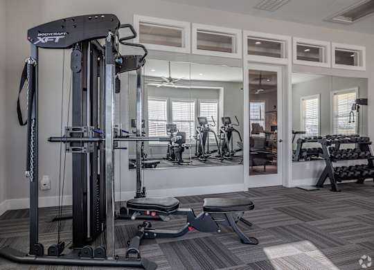 A gym with a variety of equipment including a leg press machine.at The Residences at Akita Lane, Canal Winchester Ohio