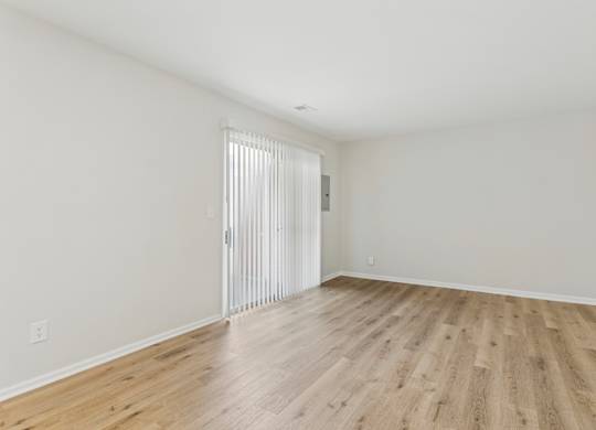 A room with a sliding door and wooden flooring.