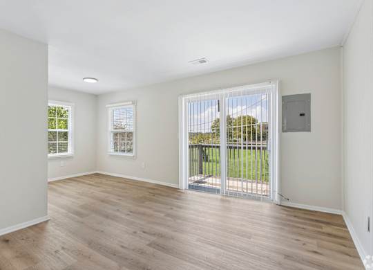 A room with a sliding glass door leading to a balcony.