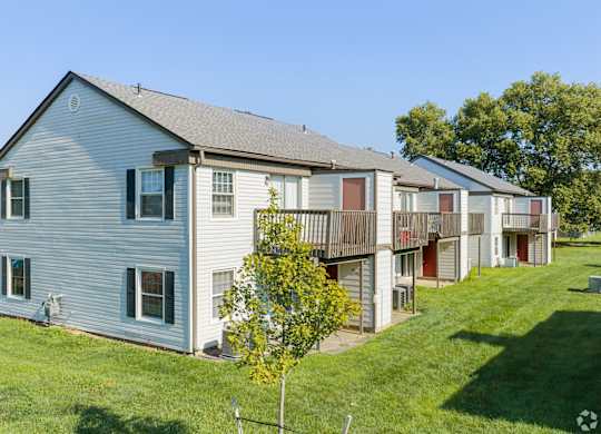A row of houses with a tree in front of the first one.