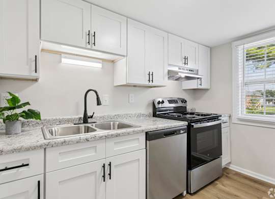 A kitchen with white cabinets and stainless steel appliances.