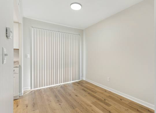 A room with wooden flooring and white walls.