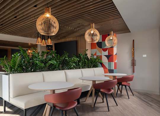 A modern dining area with white tables and chairs at The Park Apartments, Cleveland