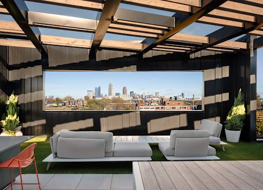 A modern outdoor seating area with a view of the city skyline at The Park Apartments, Cleveland