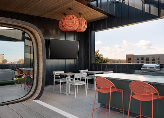 A modern outdoor bar area with a curved glass wall at The Park Apartments, Cleveland , OH