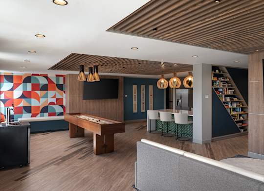 A room with a pool table and a shelf with books at The Park Apartments, Ohio