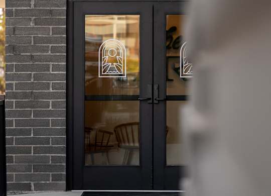 A black door with a glass window is set into a brick wall at The Park Apartments, Cleveland , OH