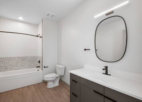 A bathroom with a white sink, toilet, and a bathtub with a shower curtain at The Park Apartments, Cleveland , OH, 44113