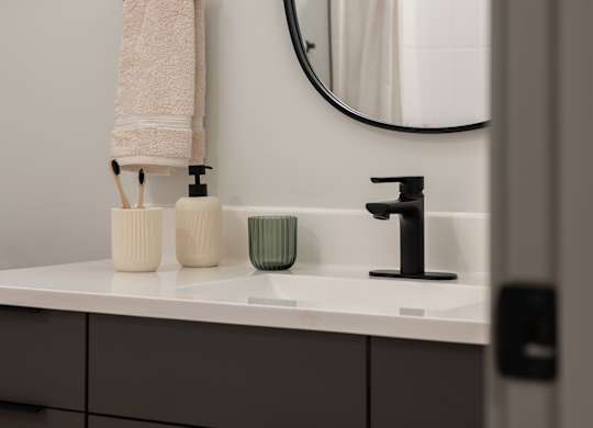 A bathroom with a white sink and a round mirror at The Park Apartments, Cleveland , OH, 44113