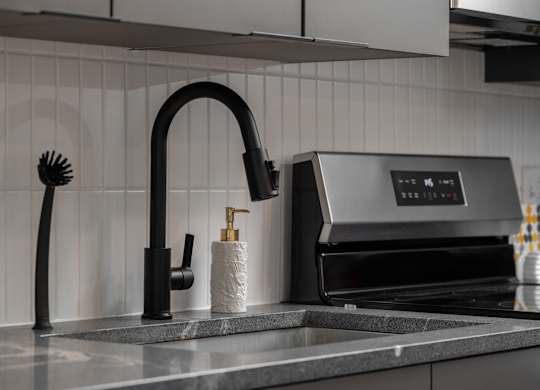 A modern kitchen sink with a black faucet and soap holder at The Park Apartments, Ohio, 44113