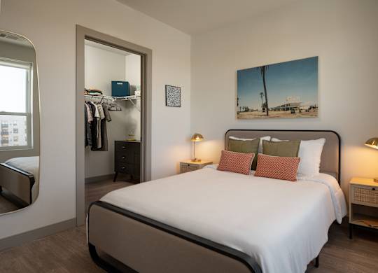 A bedroom with a large bed and a painting on the wall at The Park Apartments, Cleveland , OH