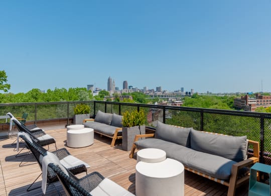 a view of the Cleveland skyline from a rooftop deck with couches and tables at TREO Apartments, Cleveland, OH