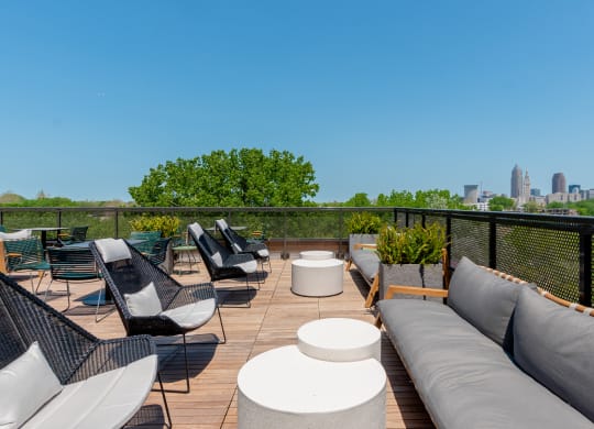 a rooftop deck with couches and chairs and a view of the Cleveland skyline at TREO Apartments, Cleveland, 44116