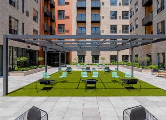 an outdoor lounge area with lounge chairs on a lawn at TREO Apartments, Cleveland, Ohio