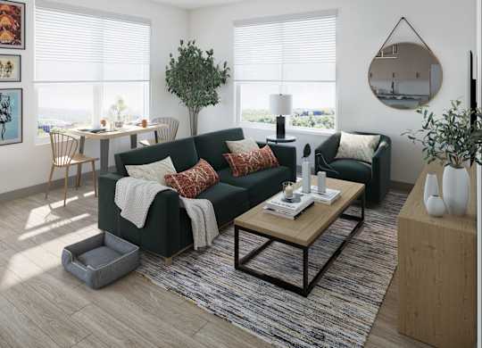 A living room with a green couch, a wooden coffee table, and a large window with blinds.
