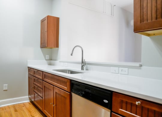 a kitchen with wooden cabinets and a white counter top and a sink