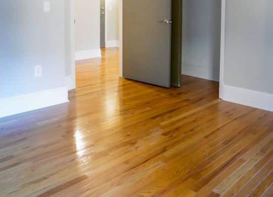 an empty living room with wood floors and a closet
