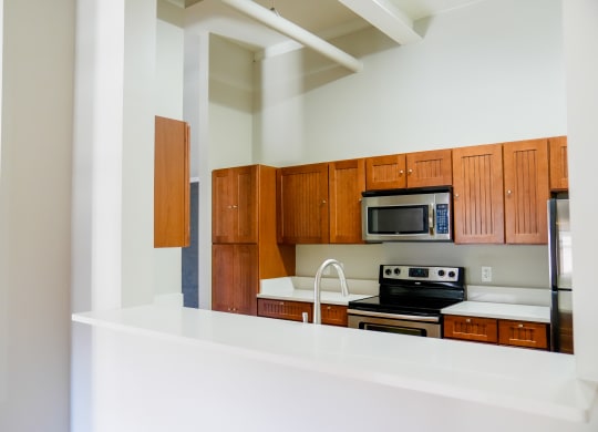 a kitchen with wooden cabinets and a stove and microwave