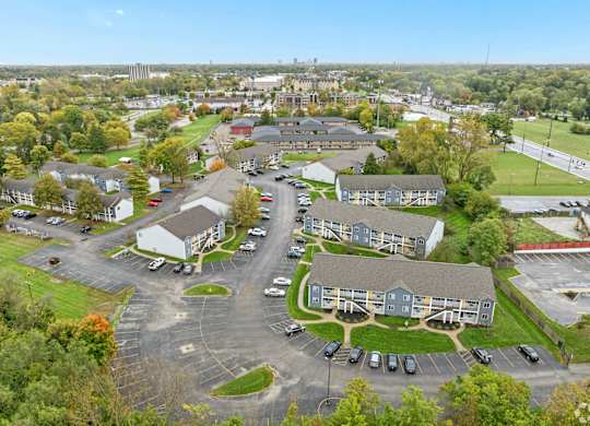 A parking lot is surrounded by apartment buildings.