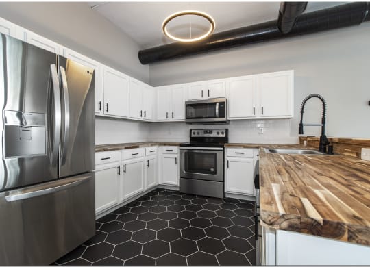 a kitchen with stainless steel appliances and a wooden counter top