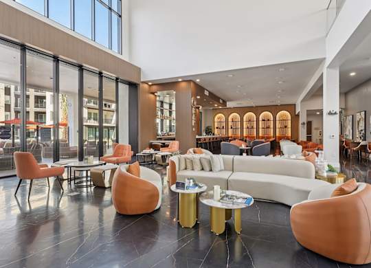 A modern living room with a white couch and orange chairs.
