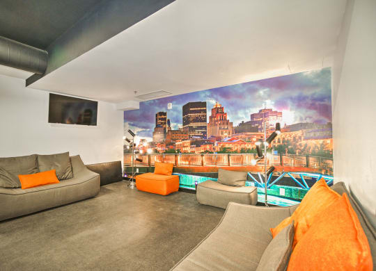 a living room with couches and a wall mural of a city
