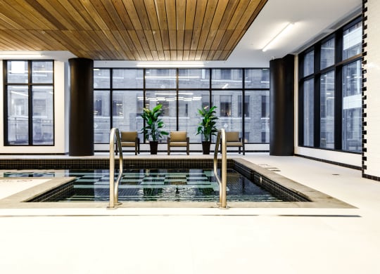 a large room with a pool and chairs in it