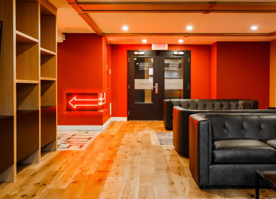 a living room with leather couches and a door to the elevator