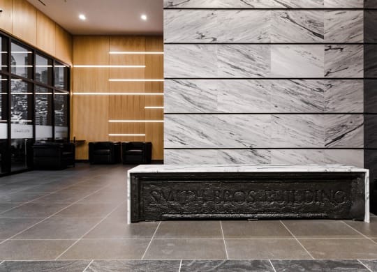 a reception desk in the lobby of a building with marble walls