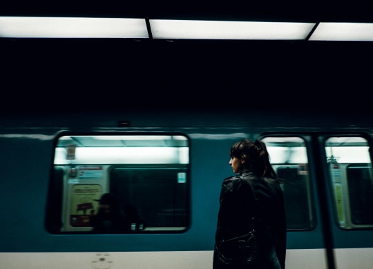 a woman standing in front of a subway train