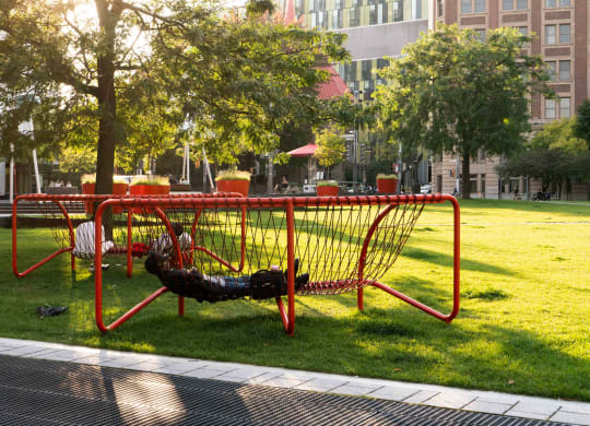 a person laying on a swing in a park
