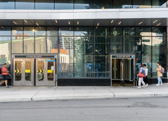 people walking in front of a building with doors