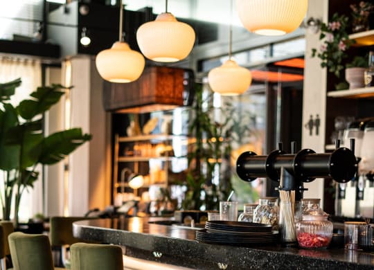 a bar with bar stools and a coffee machine in a restaurant