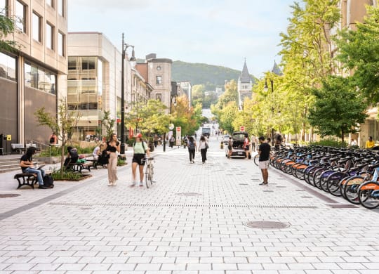 people walking down a street filled with bikes