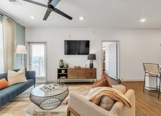a spacious living room with a couch and a TV at Apex apartments in Colorado Springs, CO