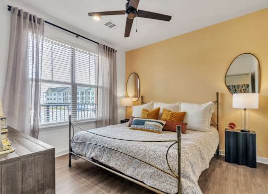 a bedroom with a bed and a ceiling fan at Apex apartments in Colorado Springs, CO