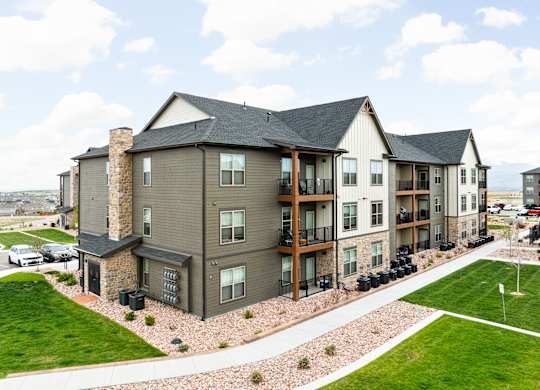 an aerial view of an apartment building with green grass and a parking lot