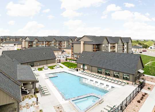 an aerial view of a swimming pool with apartments in the background