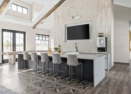 a kitchen with bar stools and a tv on the wall